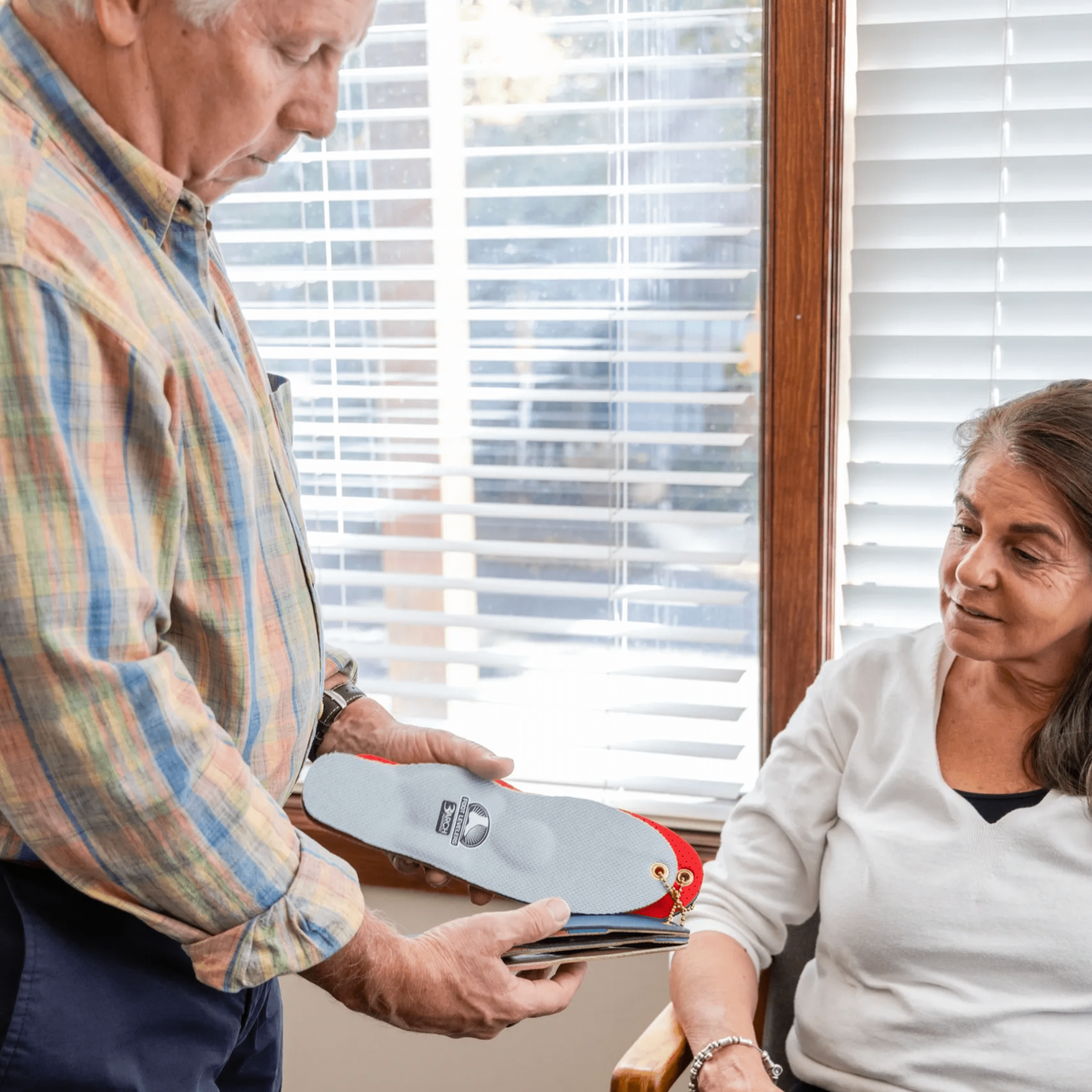 Dr. Tom fitting custom foot orthotics with patient