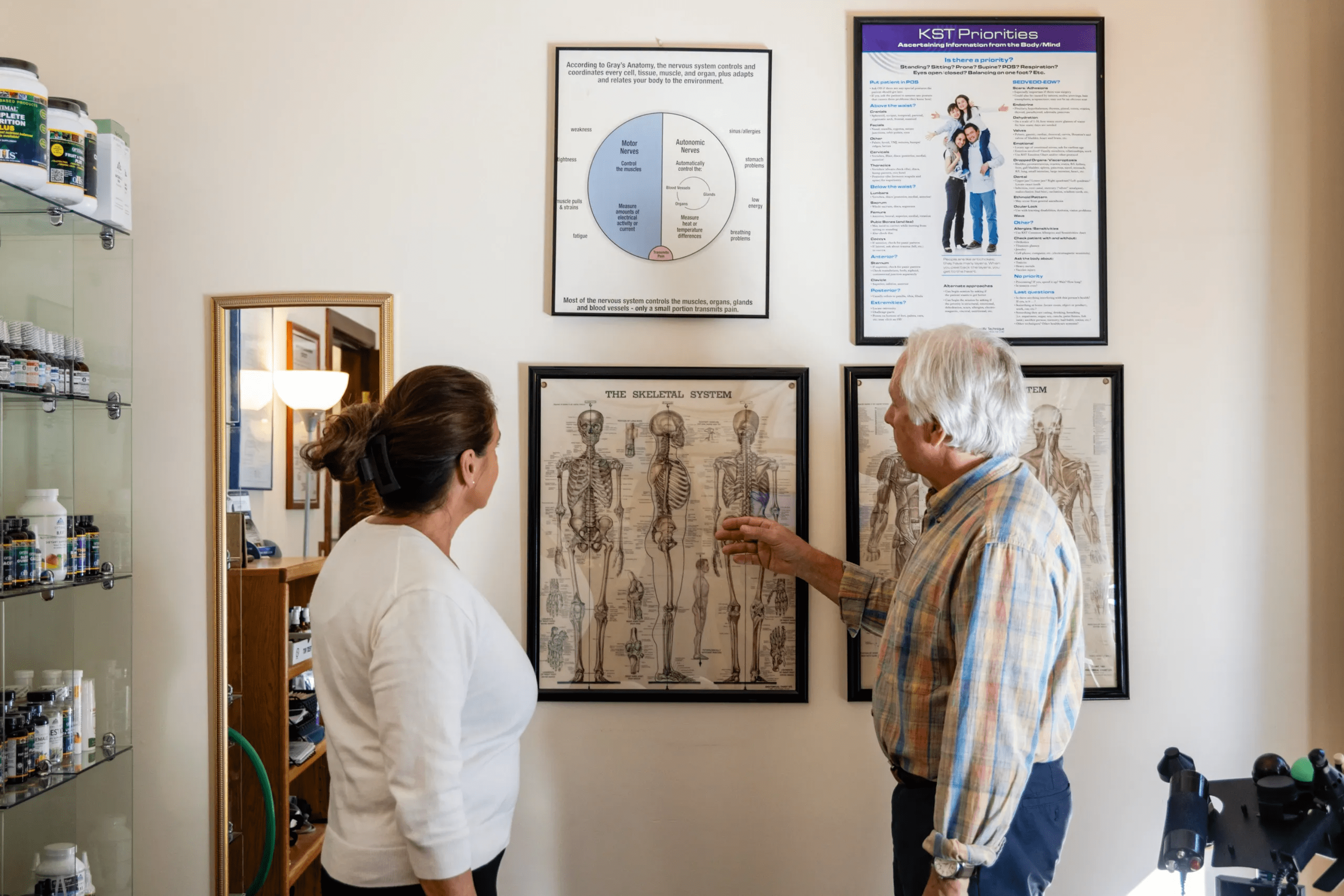 Dr. Tom teaching patient about cranial facial release technique with educational poster in Basalt, CO
